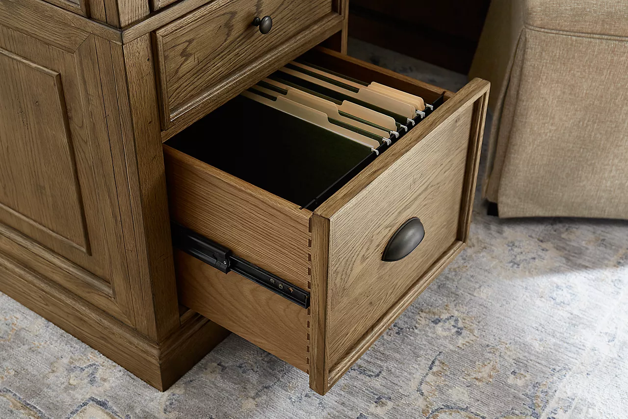 Closeup view of the Avondale II File Cabinet in Vintage Oak with one of the drawers open in a room scene.